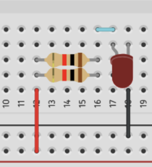 Breadboard wired with two resistors and an LED connected in parallel